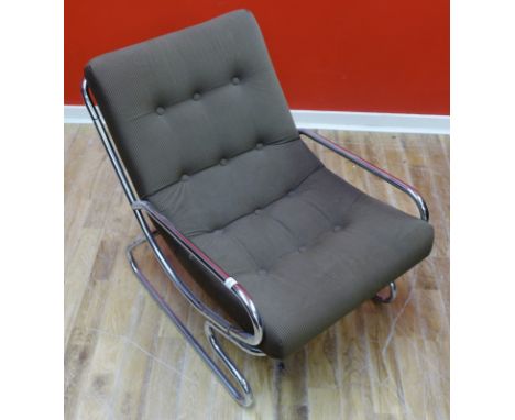 A contemporary easy chair upholstered in fawn fabric with a chrome surround.