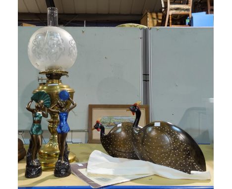 A 19th century brass oil lamp with shade and chimney; an Art Deco style pair of female figures; a pair of 'Feathers Gallery' 
