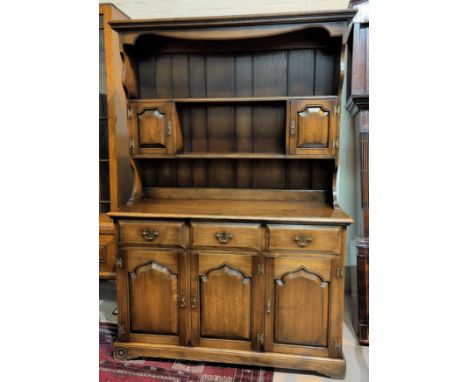 A 'Royal Oak' reproduction oak Welsh dresser with 3 drawers and 3 cupboards with carved panel decoration, rack above featurin