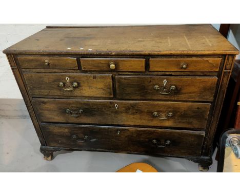 An antique stained pine chest of 7 graduated drawers, on ogee bracket feet, 133 cm 
