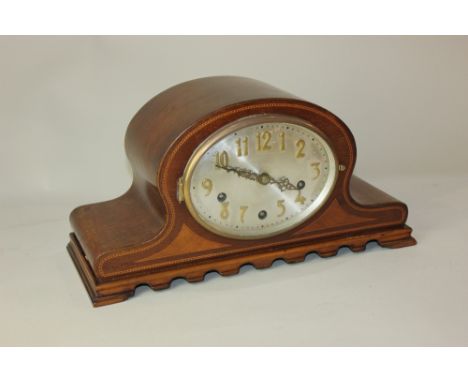 An Edwardian mahogany mantle clock, with oval dial and arch shaped case, striking on chimes, 20cm high by 38.5cm wide, with k