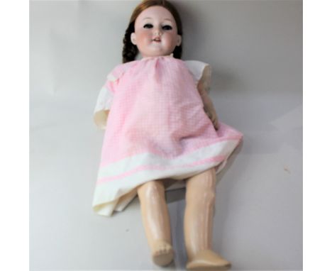 An Armand Marseille large bisque head doll, with sleeping blue eyes and eyelashes, and open mouth revealing teeth, marked Arm