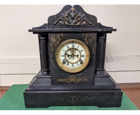 An Ansonia New York black slate mantle clock of architectural form, the circular enamel dial with visible escapement and Roma