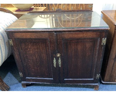 A George III oak cabinet with two panel doors enclosing two drawers and two shelves below, on bracket feet, 90cm (a/f)