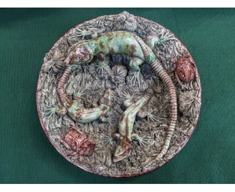 A Portuguese Palissy style wall plate decorated with lizards and beetles amongst grass, impressed mark 'M Mafra Caldao Portug