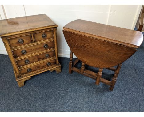 A small oak gate leg table, with oval drop-leaf top on turned supports, 79cm fully extended, together with a yew wood bedside