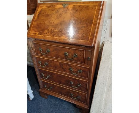 A small yew wood veneered bureau, with drop flap enclosing interior of pigeon holes and drawer, above four drawers, on bracke
