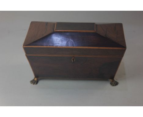 A 19th century rosewood sarcophagus shaped tea caddy, on brass paw feet, 26cm, with key