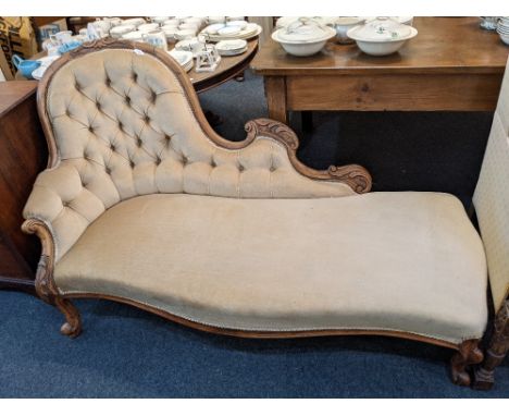 A Victorian button back upholstered chaise longue, with scroll carved frame and serpentine fronted seat, on cabriole legs