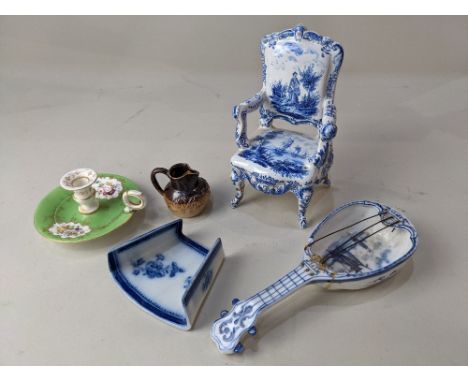 A Delft blue and white miniature model of an armchair, decorated with views of boats and a figure in a landscape, marks to ba