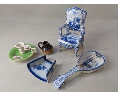 A Delft blue and white miniature model of an armchair, decorated with views of boats and a figure in a landscape, marks to ba