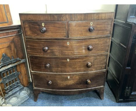 An early 19th century bowfront chest of two short over three long drawers with knob handles and black ebony line inlay, on sp