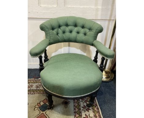 A 19th century green upholstered button back tub chair with turned supports and legs on castors