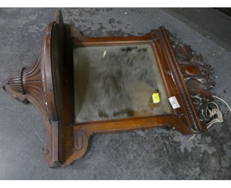 Ornate wooden mirror with shelf below 