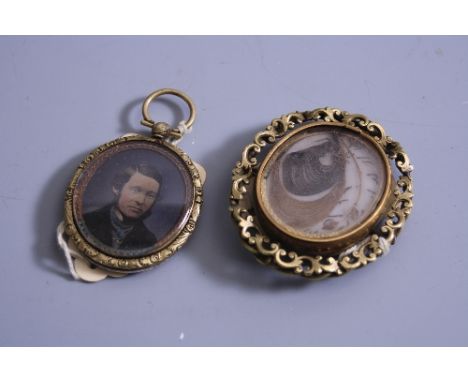 TWO VICTORIAN PINCHBECK BROOCHES, a double sided mourning brooch of oval form containing locks of hair within scrolling borde