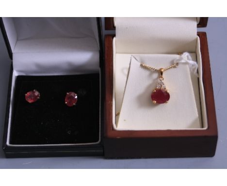 A SUITE OF JEWELLERY, to include 18ct ruby and diamond pendant, together with a pair of 18ct ruby earrings