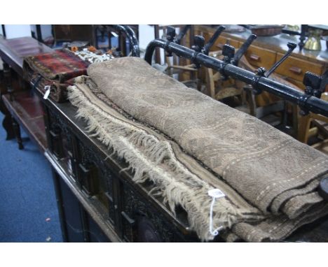 A BROWN GROUND RUG, approximate size 240cm x 170cm and a narrow length of fringed carpet decorated with beads and buttons, ap