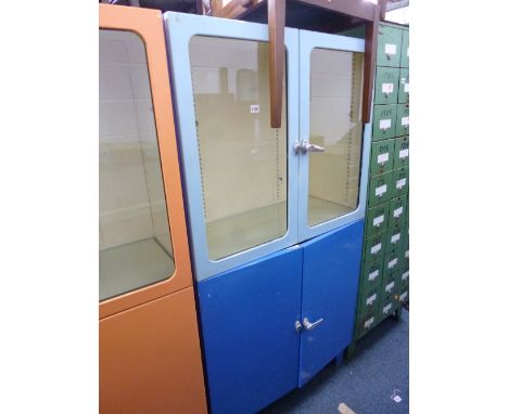 A PAINTED METAL FOUR DOOR CABINET, the glazed upper doors revealing adjustable glass shelves above two further solid doors re