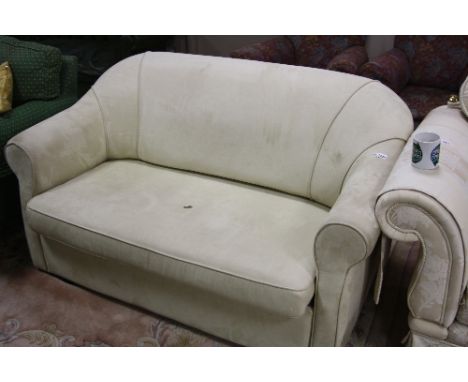 A BEIGE UPHOLSTERED TWO SEATER SOFA BED