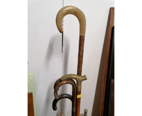 Brass stick stand containing five sticks, one stick with silver collar and tip