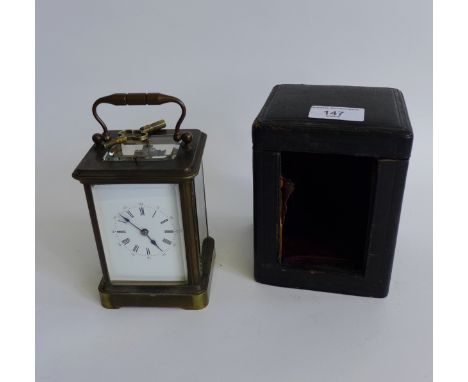 A brass cased carriage clock , the white enamel dial with  Roman numerals, complete with key and case, 
