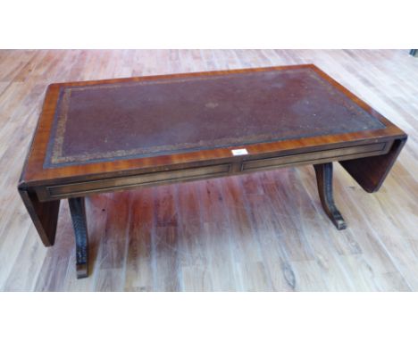 A reproduction mahogany drop leaf sofa table with green leather skiver to top raised on pad feet, 106 x 43cm