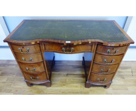 A reproduction mahogany twin pedestal desk, having green skiver to top above central drawer flanked by two banks of four draw