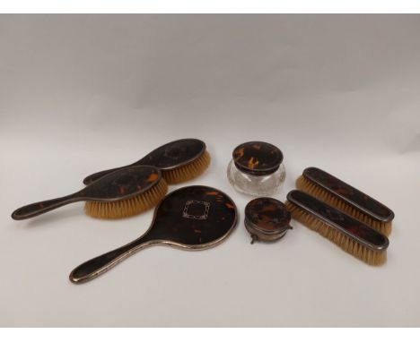 A tortoiseshell and silver dressing table set comprising of brushes, mirrors, boxes etc. (7) 