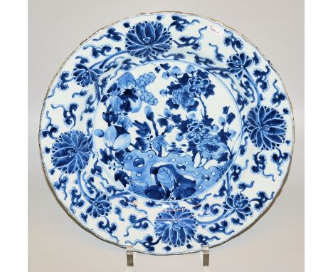 Großer Blauweiß-Teller der Kangxi-Zeit, China um 1700Porzellanteller mit Wellenrand, im Spiegel bemalt mit einem Arrangement 