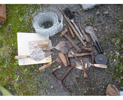 A good quantity of stone mason's/bricklayer's tools including a mortar board, a rendering float, a bolster chisel, two mason'