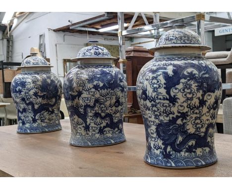 TEMPLE JARS, a set of three Chinese export style, blue and white ceramic, dragon decoration, 44cm at largest. (3) 