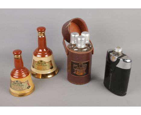 A leather cased triple flask set, chrome flask with leather case and two Bells Whisky bell decanters.  