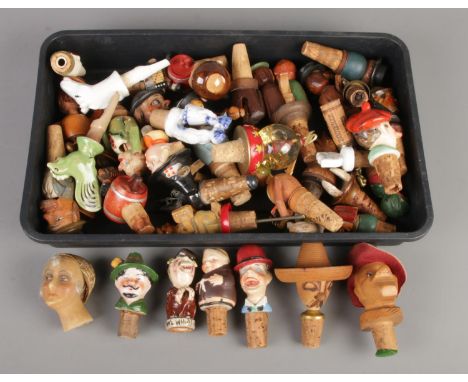A tray of novelty bottle stoppers. Including wooden, wax, ceramic examples, etc.  