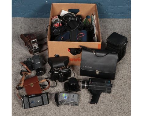 A box of cameras and equipment. Including Olympus, Bell &amp; Howell, Kershaw King Penguin bellows camera, etc.  