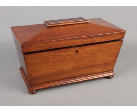 A mahogany triple tea caddy in sarcophagus form raised small ball feet.  