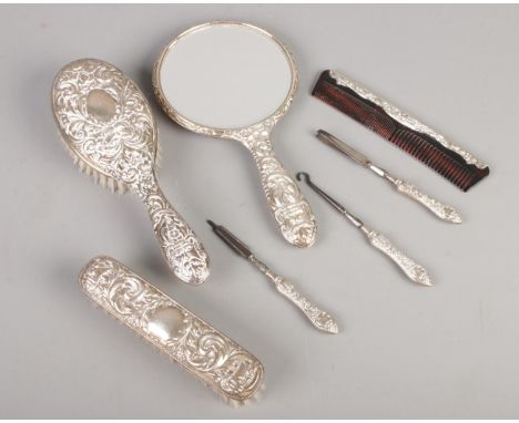 A quantity of silver mounted and silver filled dressing table accessories. Including hand mirror, button hook, comb, brush, e