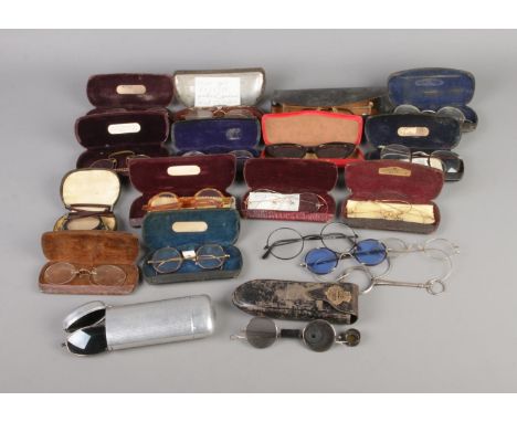A quantity of vintage spectacles, most with cases to include pair of lorgnettes and opticians glasses.  