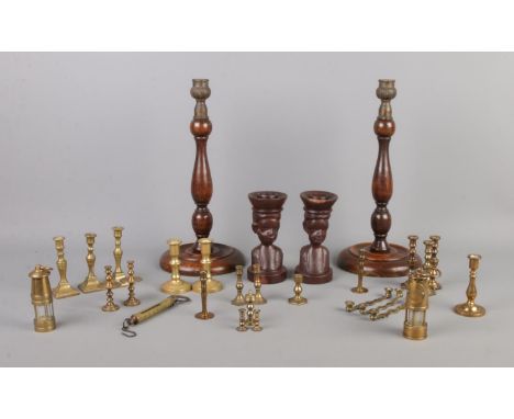 A collection of mainly miniature brass candlesticks, together with a larger turned wooden pair, miniature miners lamps and mi