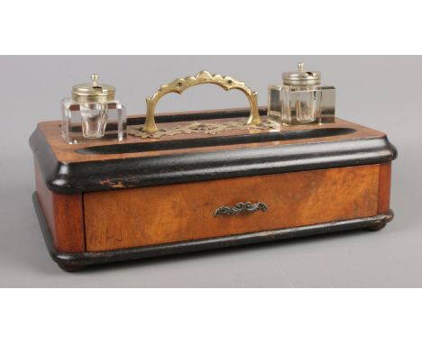 A walnut, mahogany and ebonised desk tidy, with brass handle, two inkwells and lower pen draw. Height: 14cm, Width: 31cm, Dep