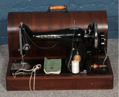 A dome top cased singer sewing machine, with manual.  
