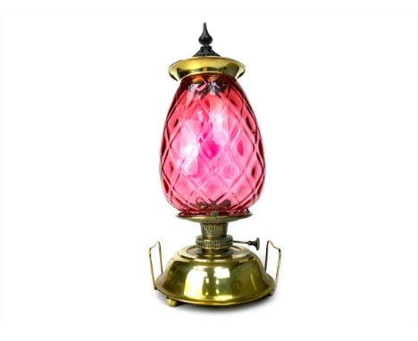 BRASS OIL LAMP, with squat reservoir and large ovoid crimson glass shade, 60cm high