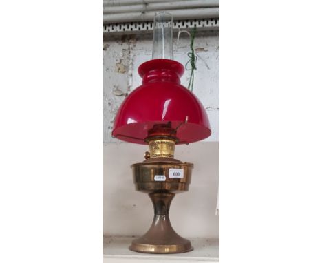 Brass oil lamp with red glass shade  