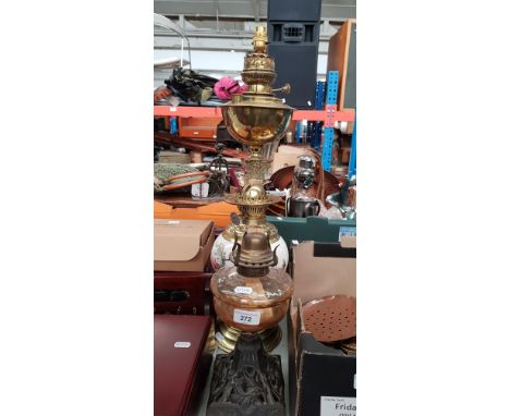 Three oil lamps including one Veritas brass lamp on Corinthian column base (converted to electric) together with two others. 