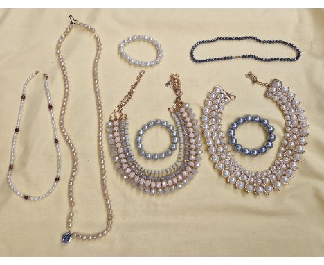 A bag of mostly pearl effect necklaces  