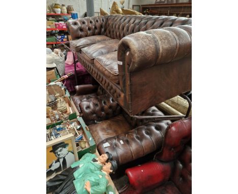 A brown leather Chesterfield suite comprising three seater sofa, wingback armchair and club chair. Condition- some general we