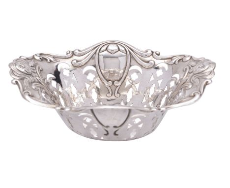 An English Art Nouveau silver bonbon dish, George Wish, Sheffield 1908, of shaped oval form, the wavy rim either end embossed
