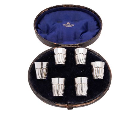 A cased set of six Victorian silver whisky tots, Jesse Earls London 1889, part swirl and flued decoration, set in an oval cas