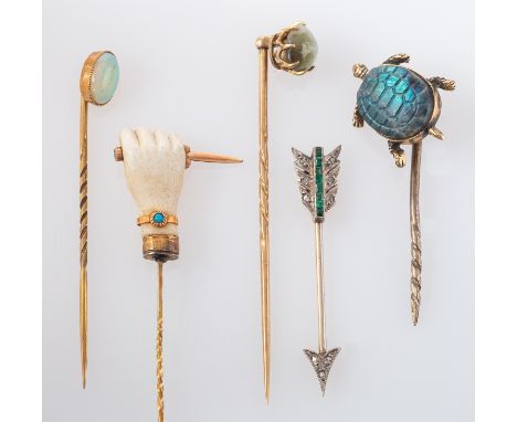 Five gemset pins, including an arrow-shaped diamond and emerald pin; a chatoyant chrysoberyl pin; an opal pin; a labaradorite