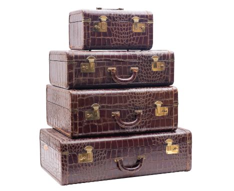 A mid 20th century American four piece crocodile skin set of travel cases, comprising a vanity case with red lined interior, 