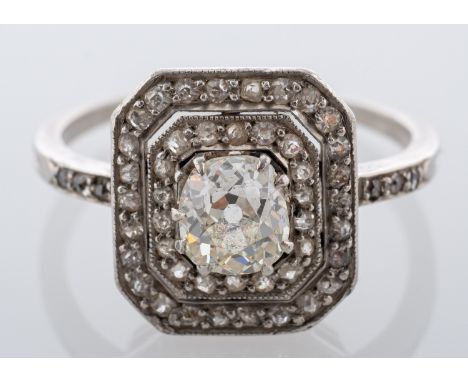 An Art Deco diamond cluster ring, the octagonal plaque, claw set at the centre with a cushion shaped old mine diamond within 